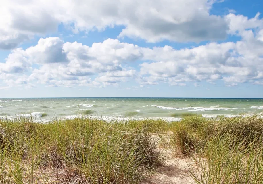 Beach with grassy dunes and blue sky
